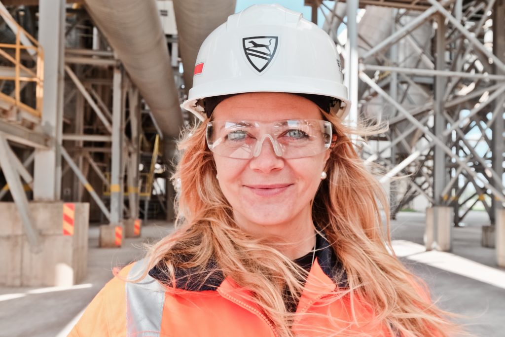 Woman wearing protective glasses and helmet in SCHWENK Latvija cement plant